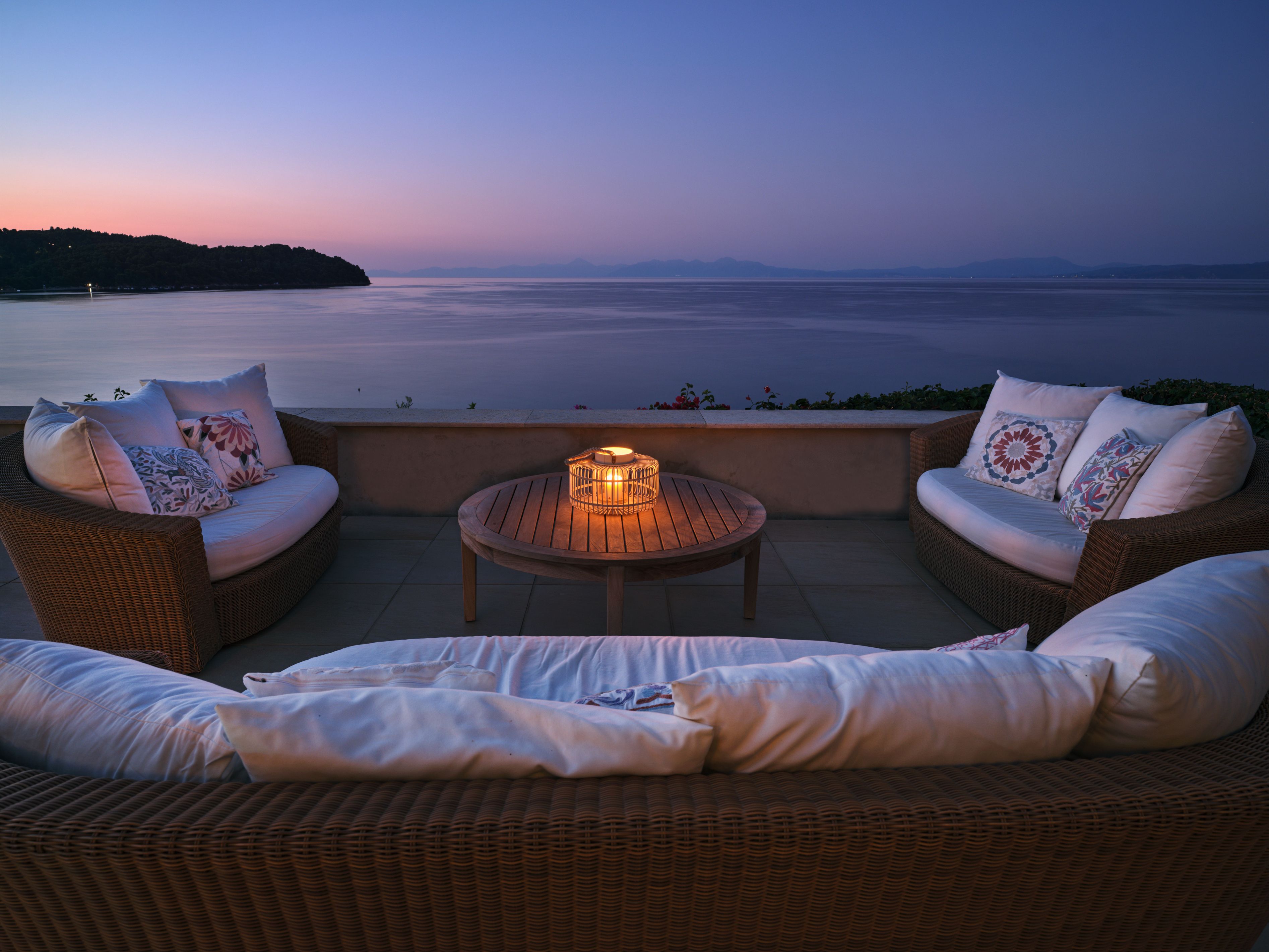 Wicker sofas on the terrace at sunset