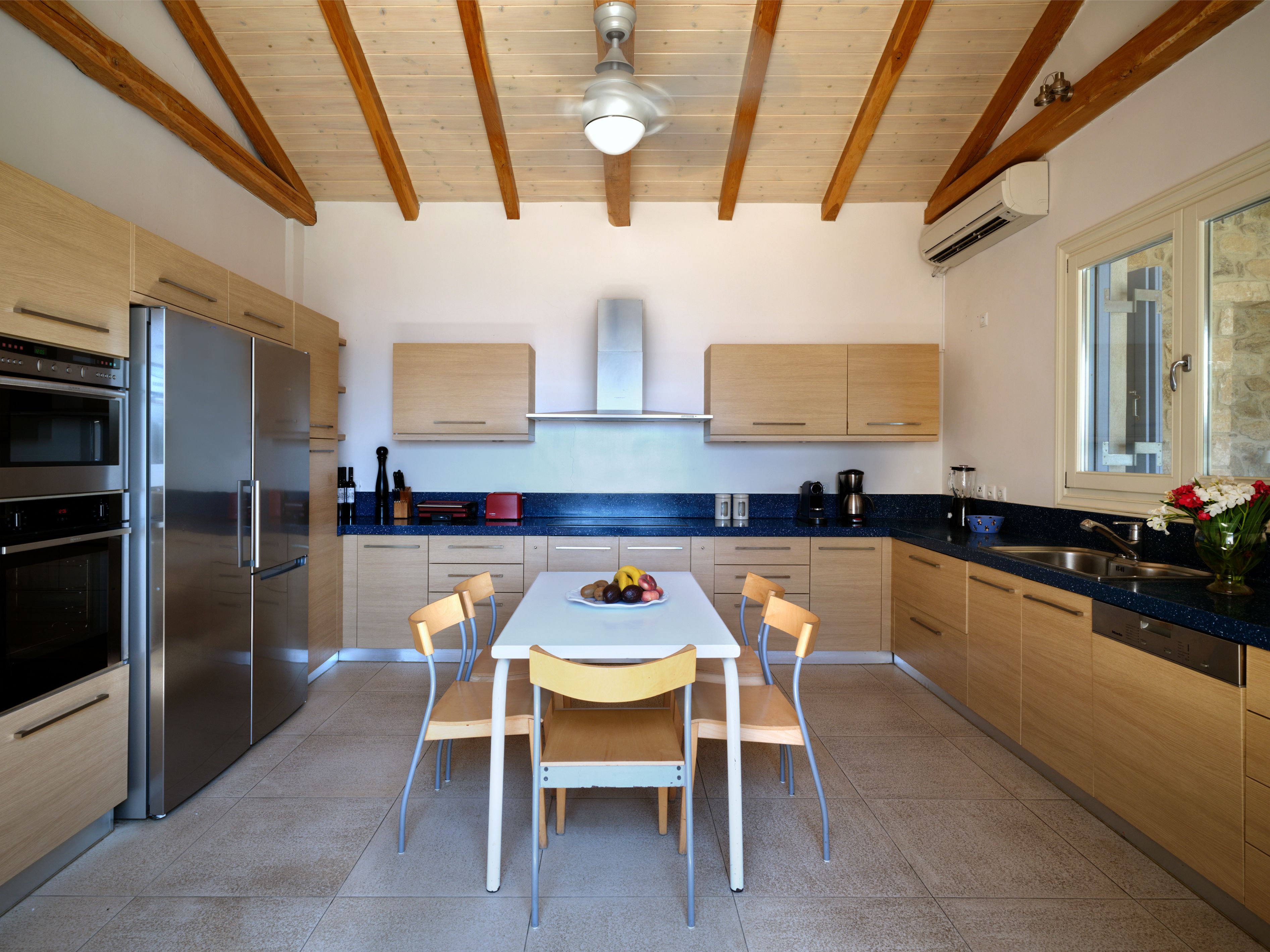 The kitchen, with a dining table under the beamed ceiling