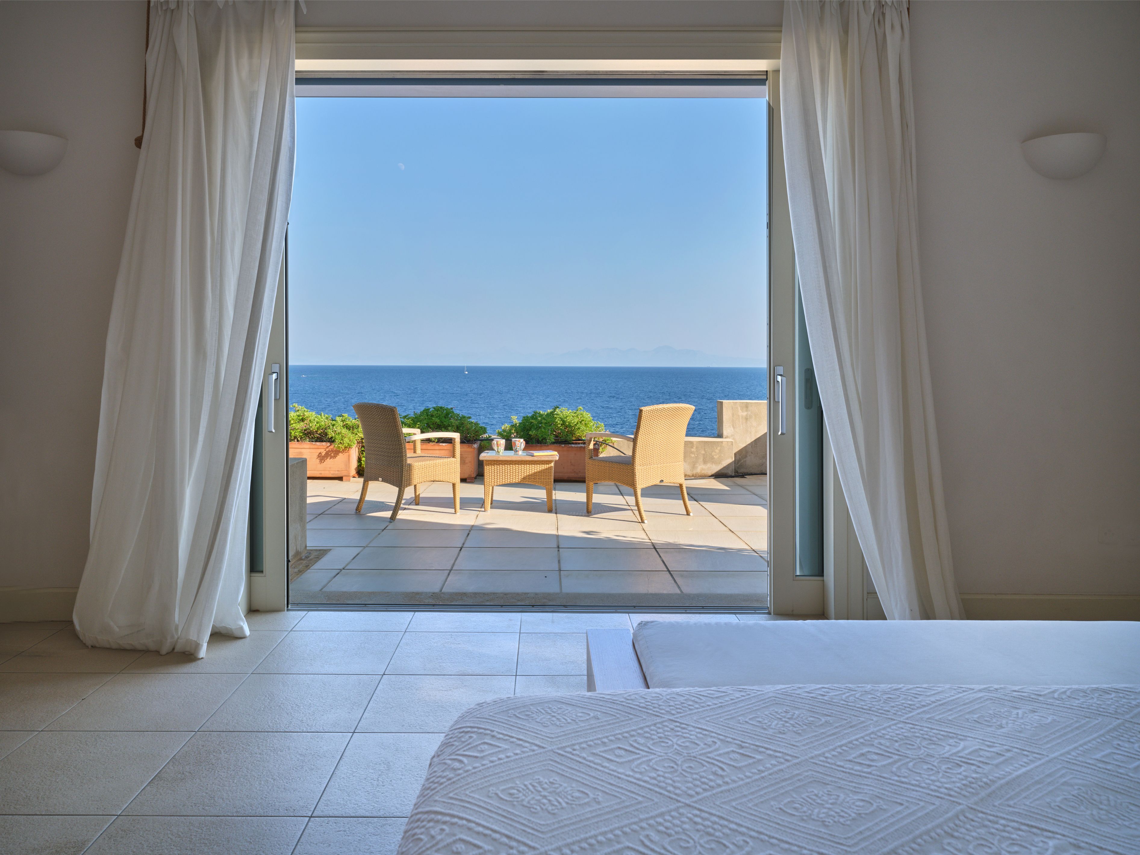 The sea view from the master bedroom through open doors to the veranda