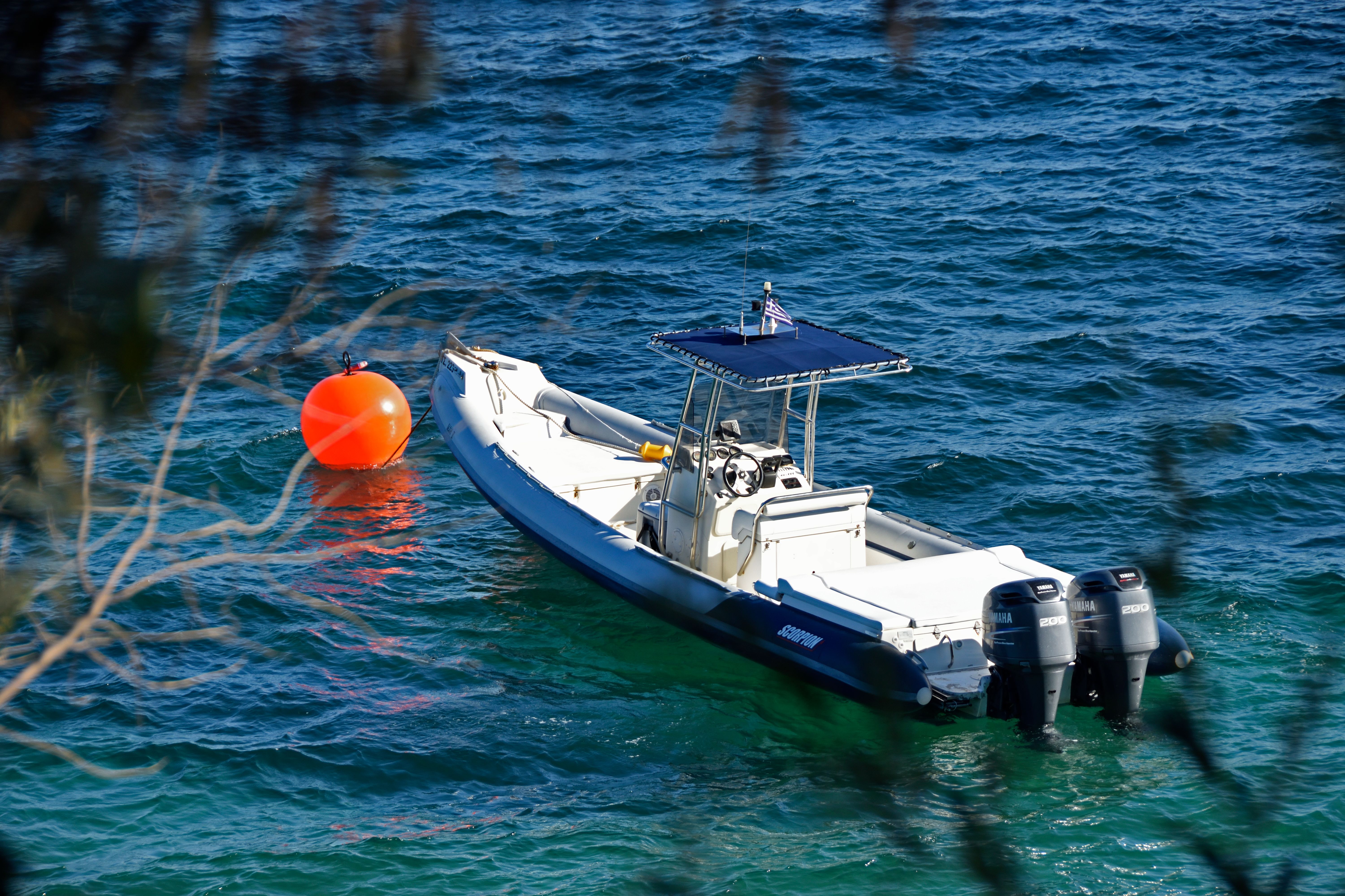 A RIB tied to an orange mooring buoy in the bay
