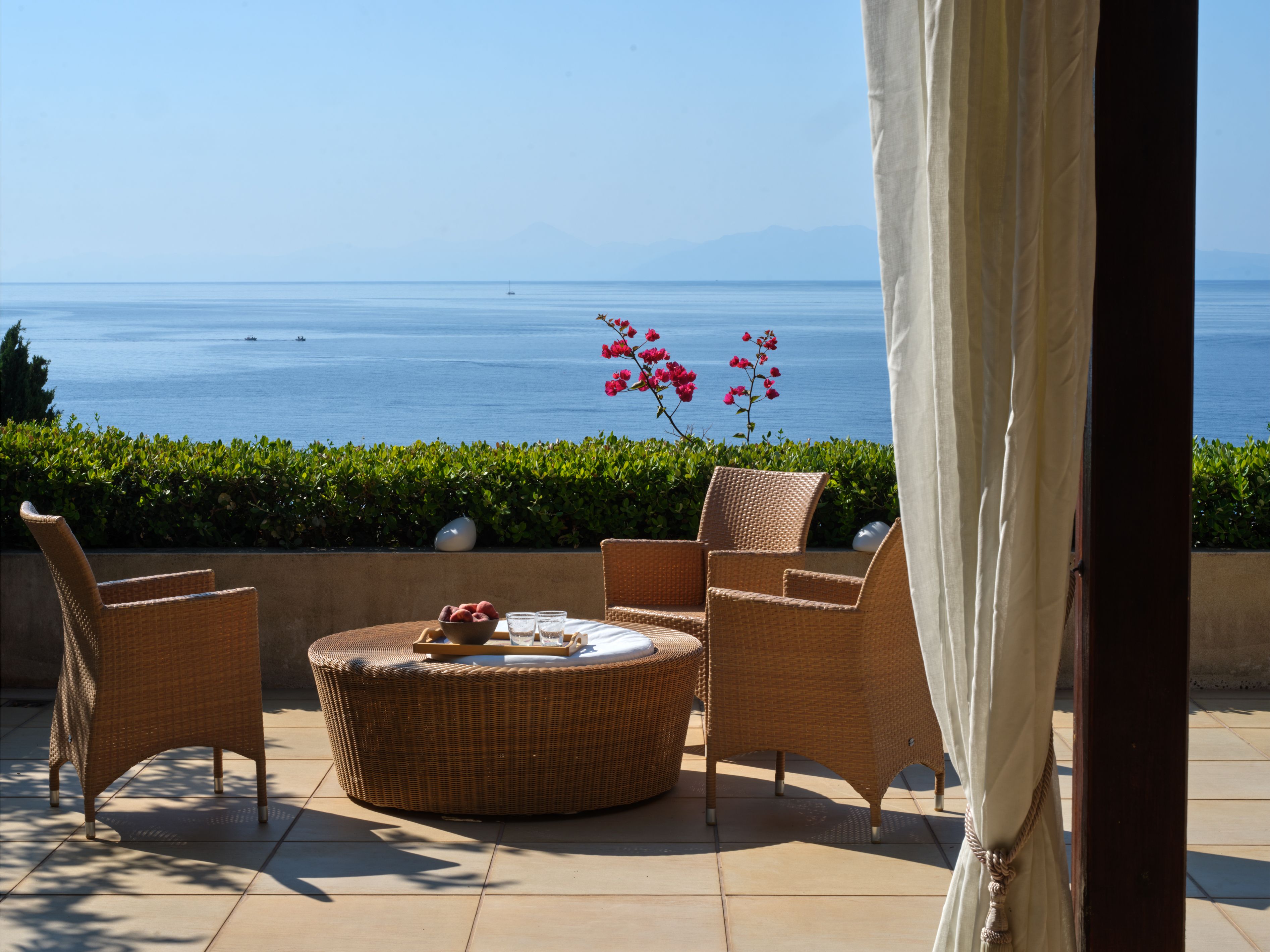 Wicker chairs on a terrace with a sea view
